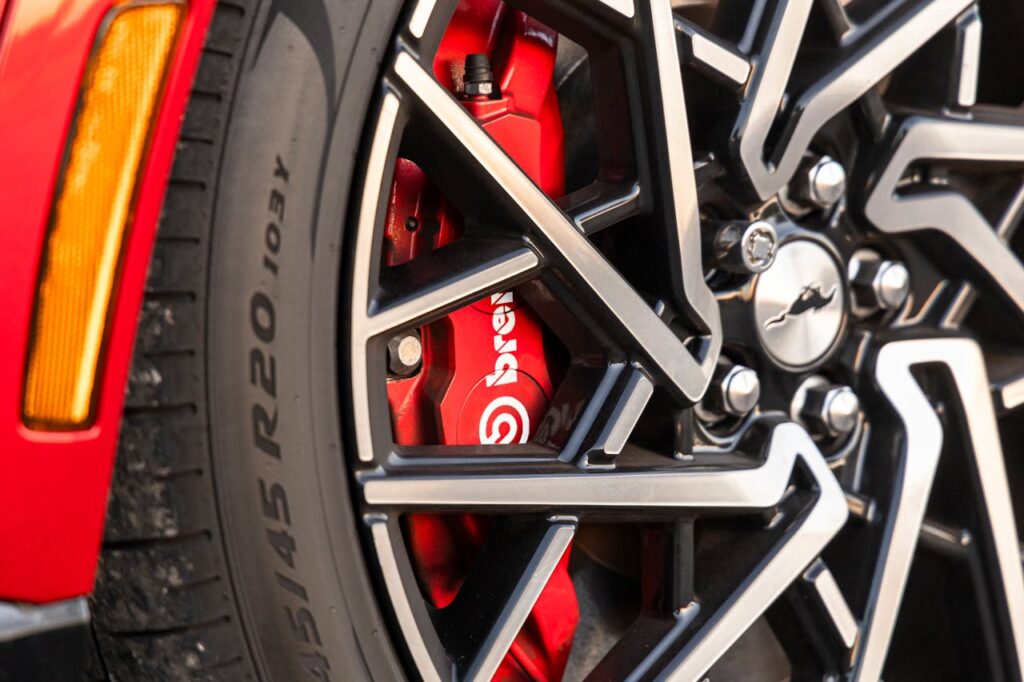 Detailed close-up of a red Brembo brake caliper and alloy wheel showcasing automotive technology.